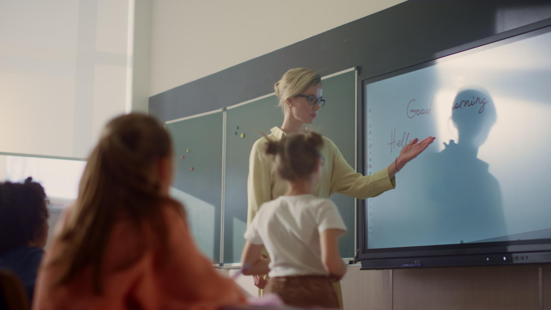 年轻教师和女学生站在教室智能板上视频的预览图