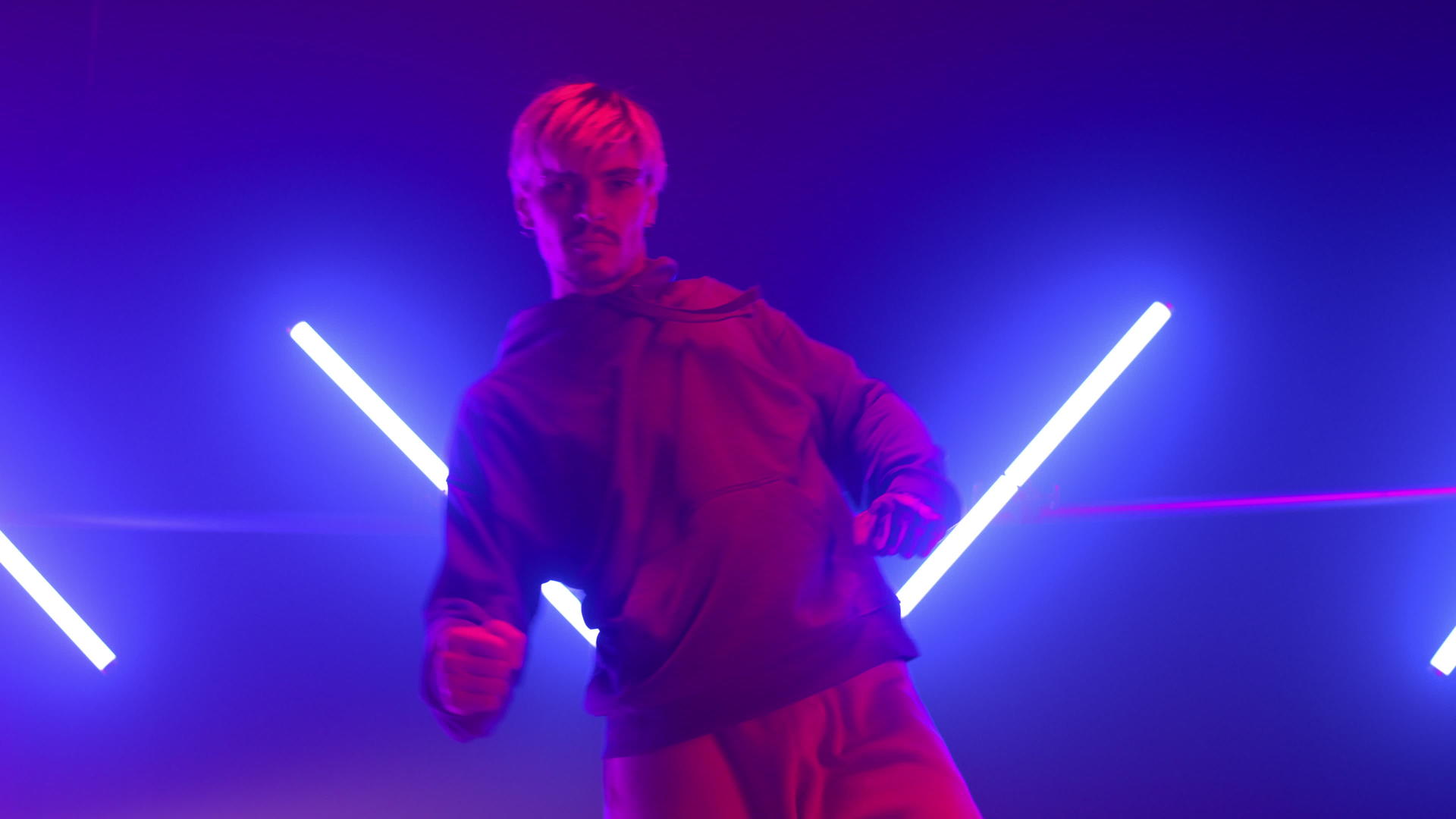 在紫外线背光舞台下富有表现力的嘻哈舞者自信地跳舞视频的预览图