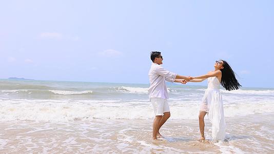 海边情侣沙滩上嬉水玩闹视频的预览图