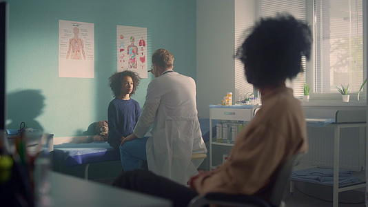 男医生在办公室诊所检查孩子在青春期前的反应母亲在等待视频的预览图