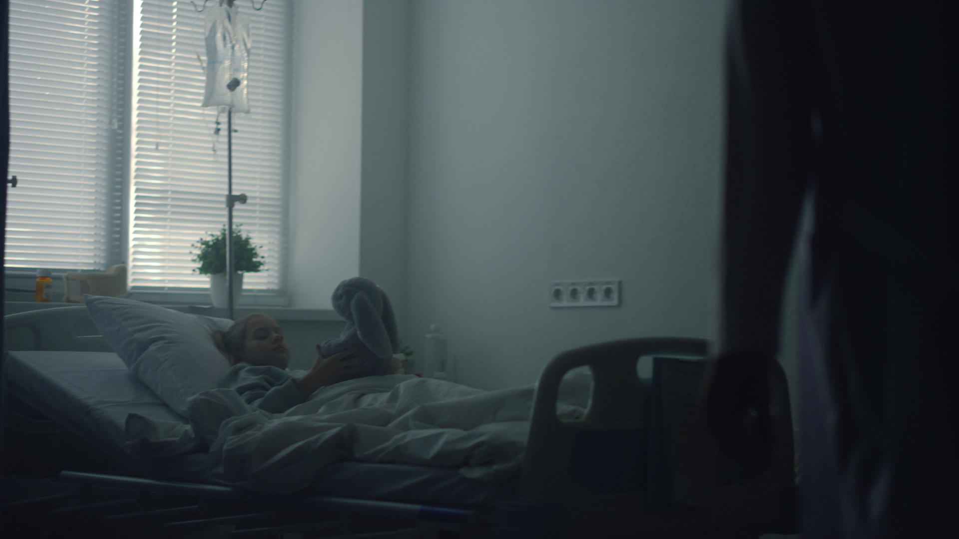 小女孩躺在病床上玩毛绒玩具医生在病房看望病人视频的预览图