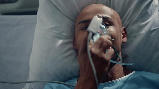 患者戴上氧气面罩躺在床上手指上的脉搏血氧仪视频的预览图