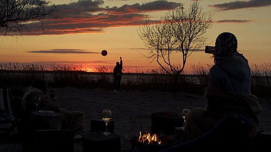 日落海岸线背景下的朋友组在海滩野餐视频的预览图