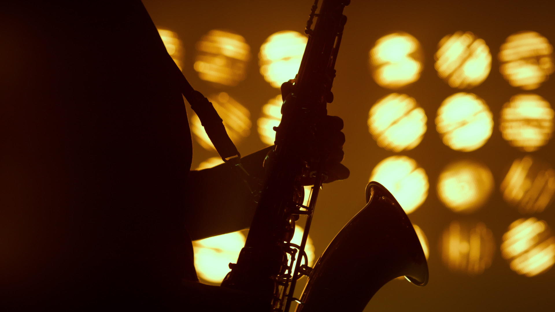 萨克斯管演奏者的剪影手在聚光灯下演奏乐器视频的预览图