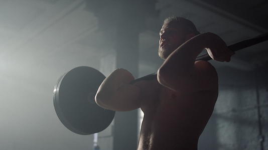 男性肌肉举重运动员在健身房举重视频的预览图