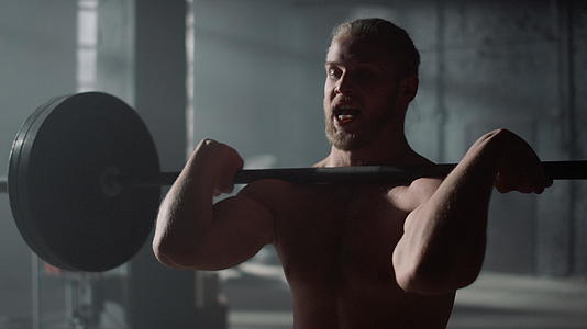男人在健身房举重做肩压锻炼视频的预览图
