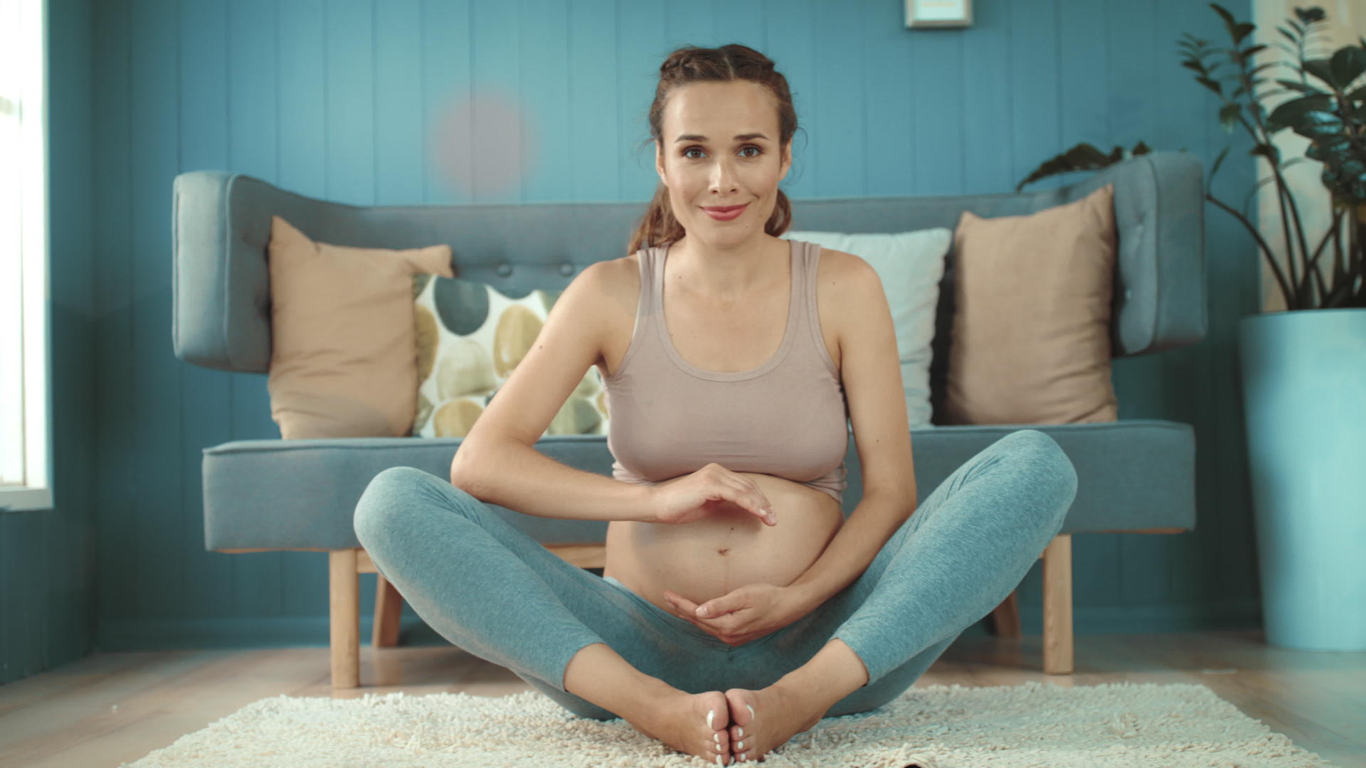 孕妇坐在家里做瑜伽视频的预览图