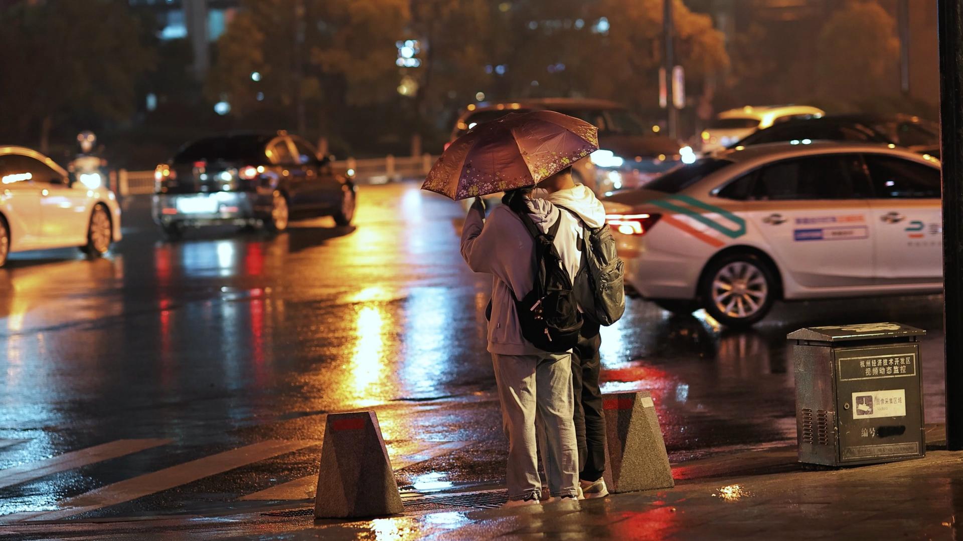 雨夜撑伞过马路的情侣视频的预览图