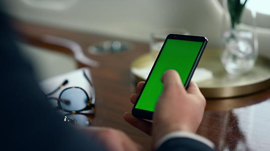男性白领手刷绿色智能手机屏幕特写视频的预览图