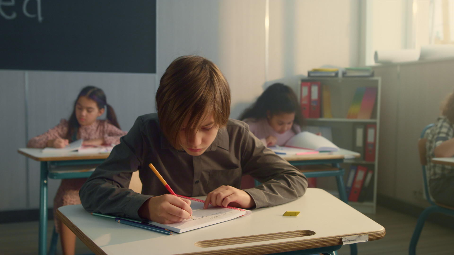 小学生在课堂上记笔记写在笔记本上视频的预览图