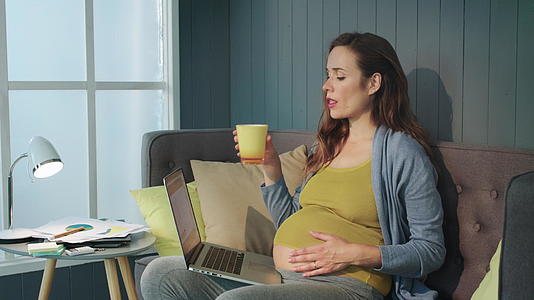 孕妇在客厅工作喝水视频的预览图