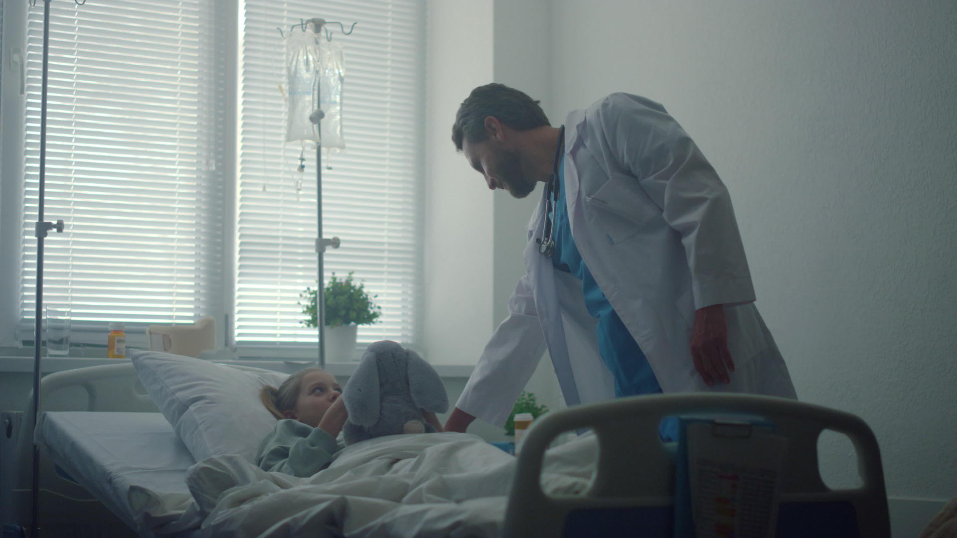 医院病房的医生检查了拥抱毛绒玩具的生病女孩视频的预览图