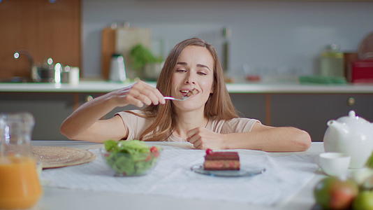 在家减肥的女性在吃饭后选择吃蛋糕视频的预览图