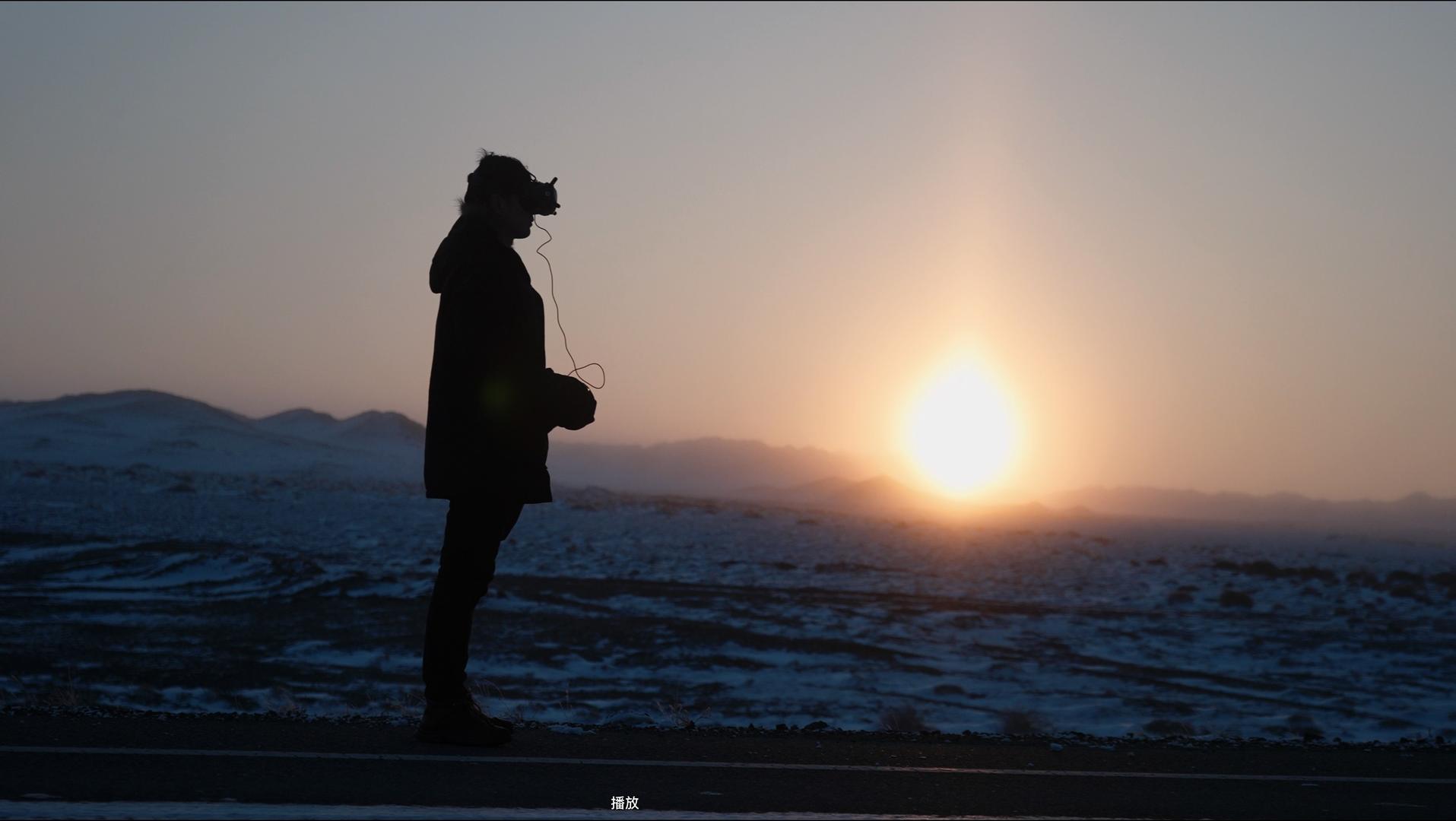 4K新疆一个人站在夕阳雪地上操作穿越机视频的预览图