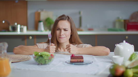 在家生活减肥的女性在吃饭后选择蛋糕视频的预览图
