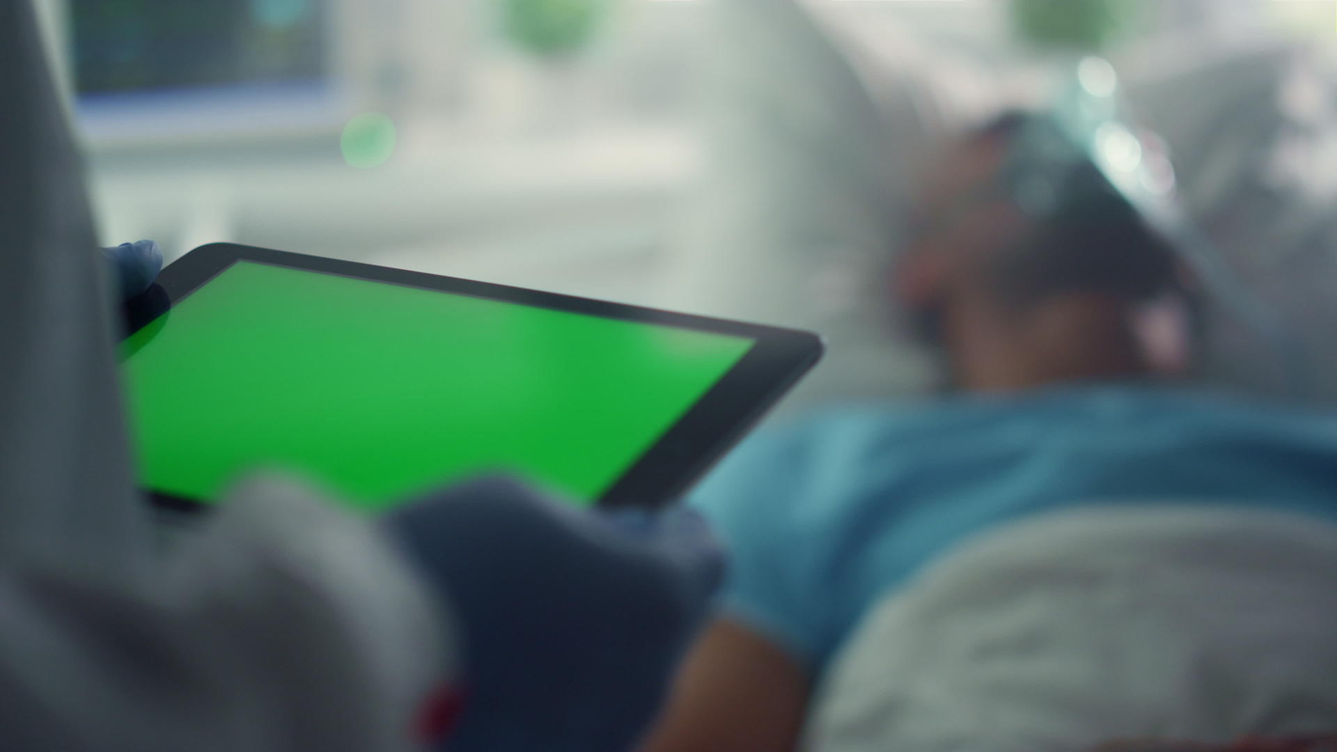 医院特写镜头中医护人员拿着绿屏平板电脑检查患者情况视频的预览图