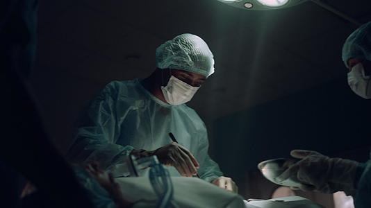 外科医生在黑暗的急诊病房做手术视频的预览图
