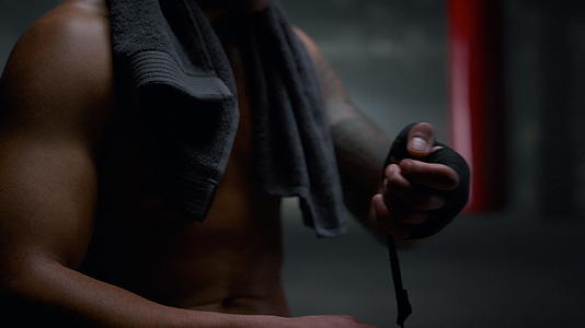 肌肉用手拉绷带包裹手准备拳击训练视频的预览图
