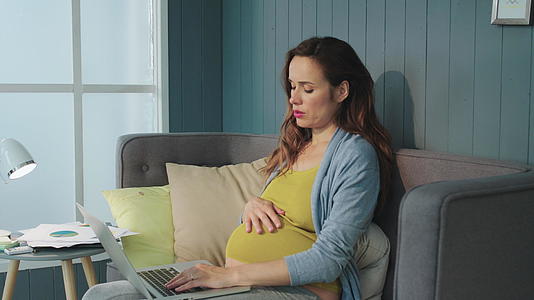 孕妇摸着肚子持续的工作视频的预览图