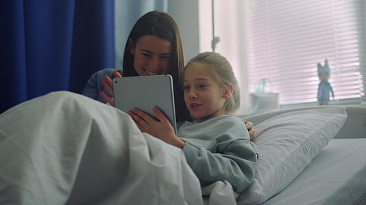 父母看望生病的孩子学习玩平板电脑视频的预览图