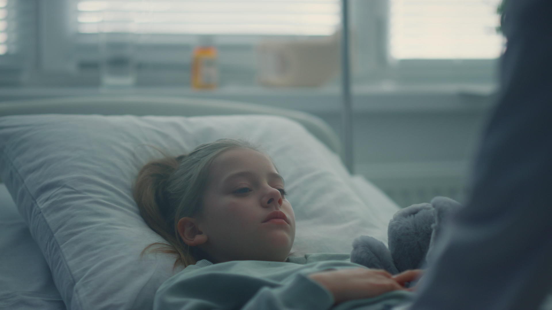 生病的小女孩躺在医院的床上拥抱着玩具视频的预览图