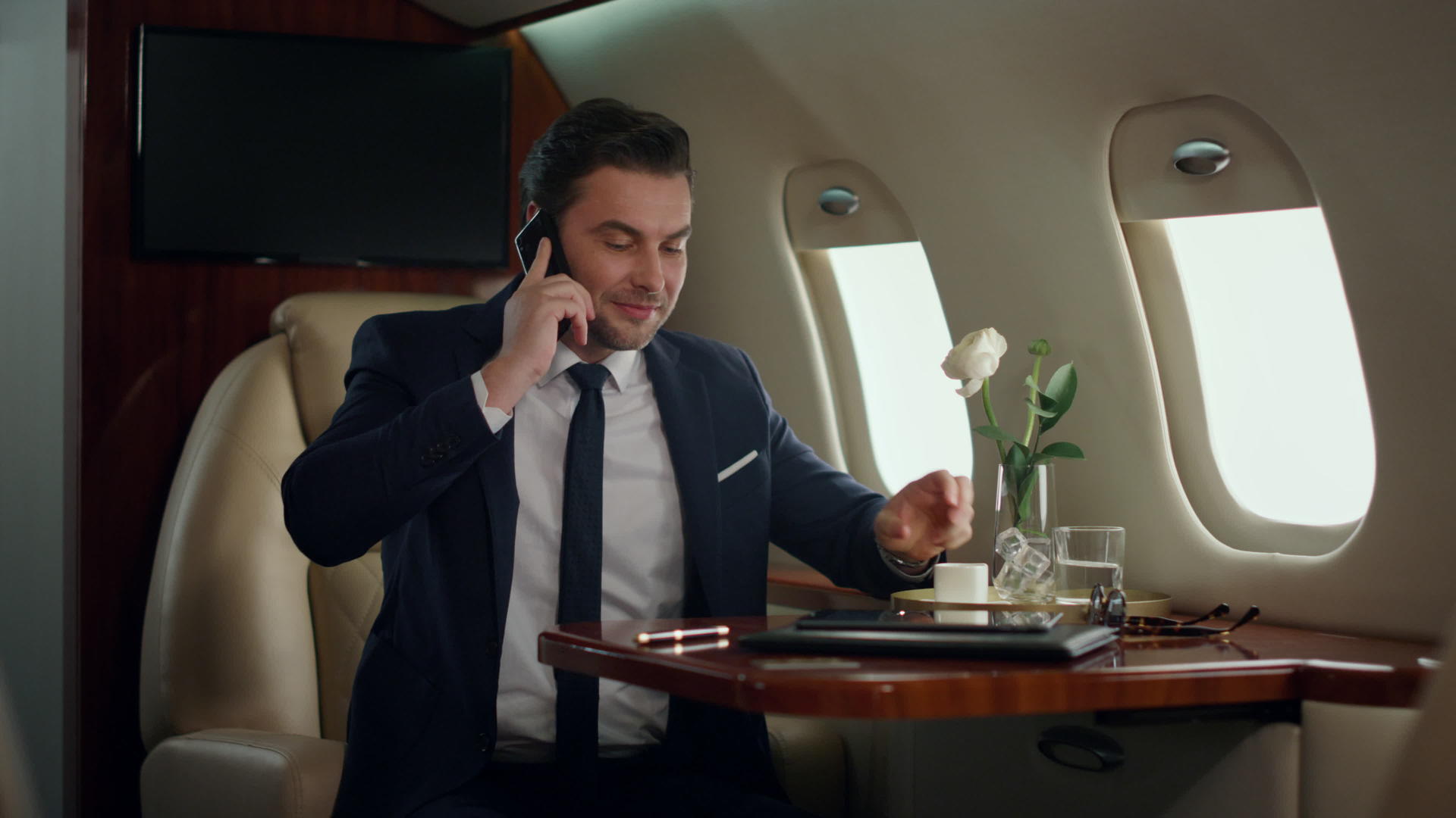 忙碌的男性白领在豪华喷气式飞机上打电话会议视频的预览图