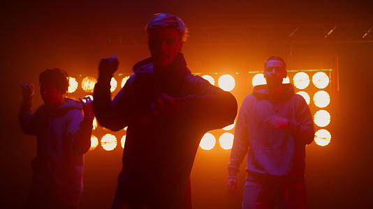 街头嘻哈年轻时尚舞者在聚光灯下表演街头风格舞蹈视频的预览图