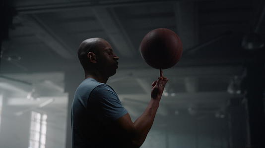 严肃的篮球运动员在健身房用手指旋转篮球肖像视频的预览图