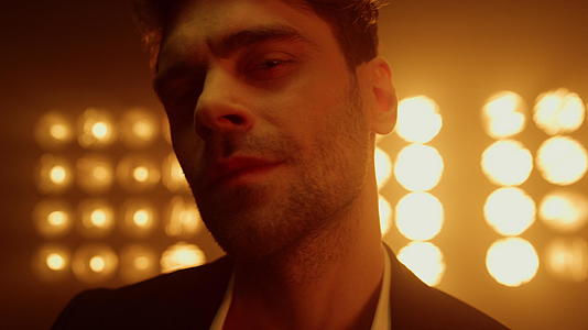 男歌手在灯光特写镜头中表现出自信视频的预览图