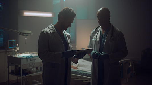 在病房里两名医生拿着平板电脑开会讨论肖像视频的预览图