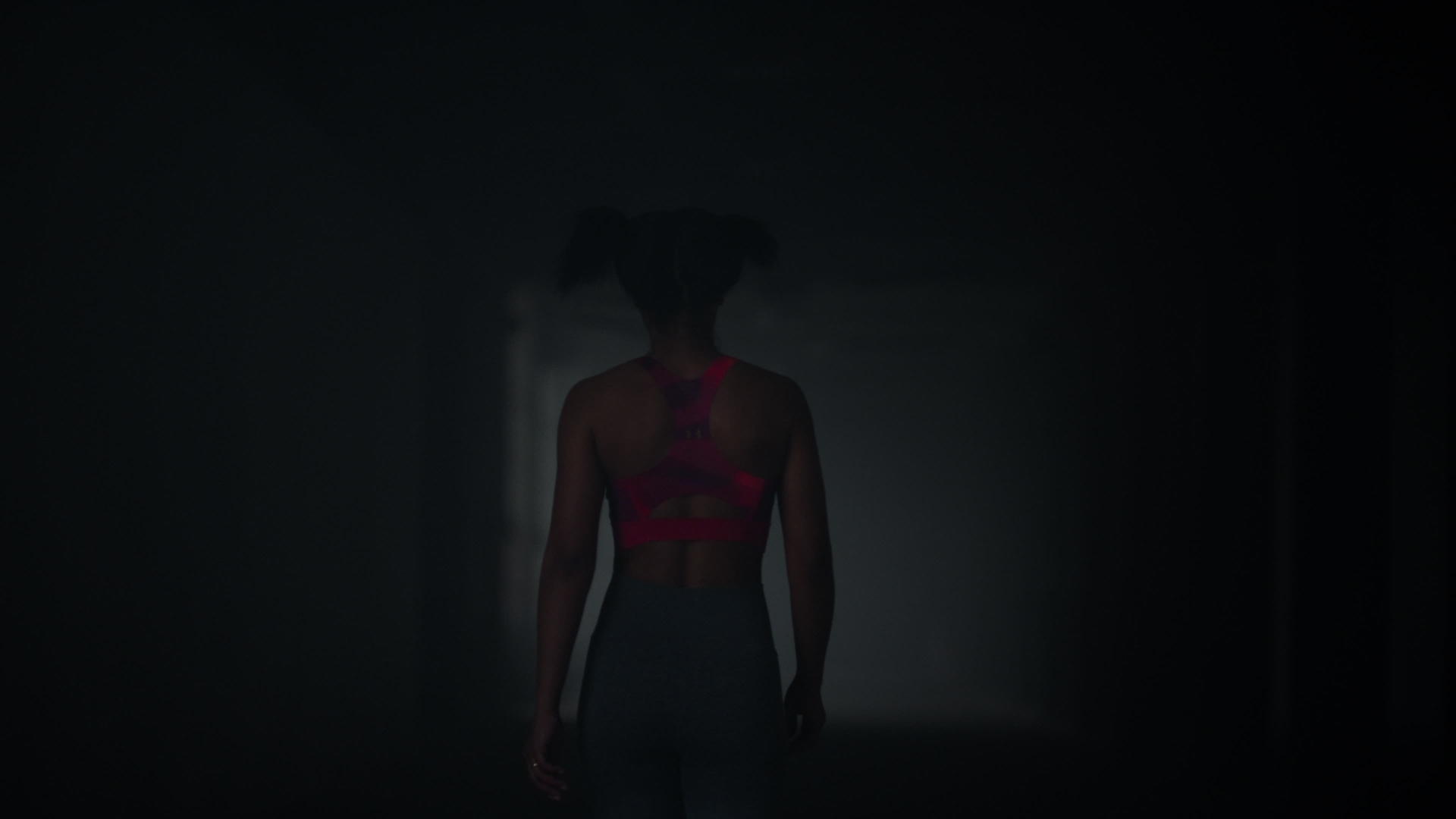 女运动员走在黑暗的走廊里视频的预览图
