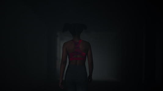 女运动员走在黑暗的走廊里视频的预览图