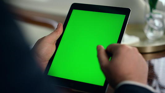 工作女性的手拿着绿色屏幕特写镜头视频的预览图