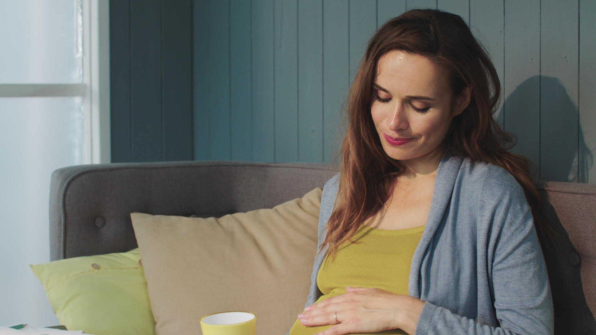 孕妇在客厅的沙发上摸肚子视频的预览图
