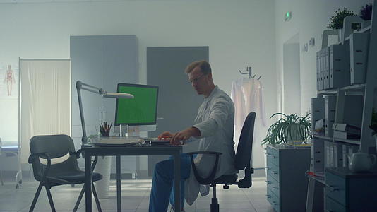 医生坐在办公室里电脑绿屏视频的预览图