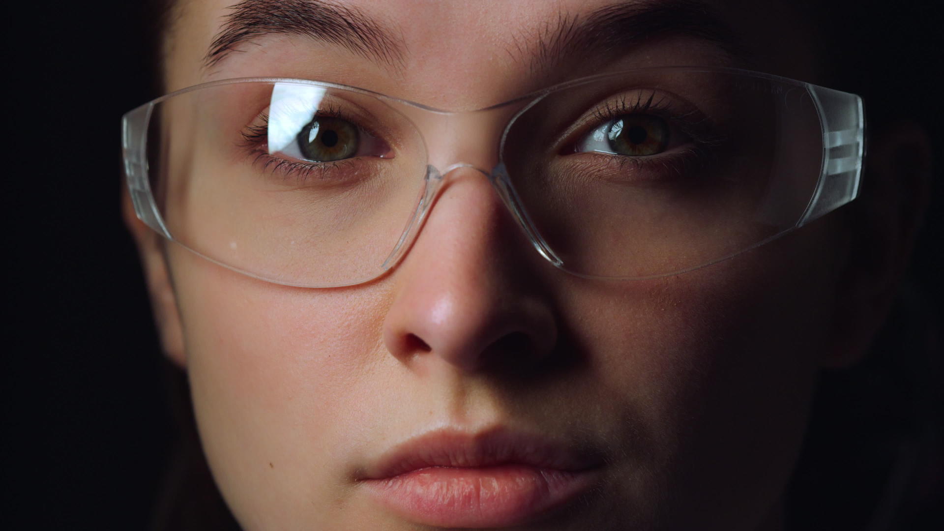 带着vr透明智能眼镜移动眼睛的女性面部特写视频的预览图