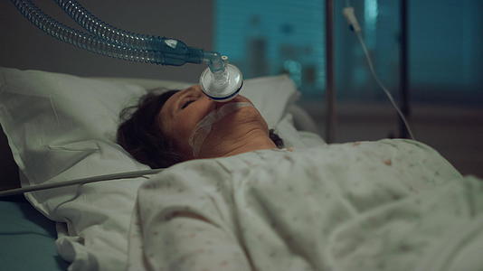 患者戴着氧气面罩躺在医院重症监护病房的病床上视频的预览图