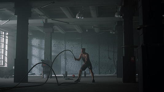 男性使用战斗绳进行健美力量训练视频的预览图