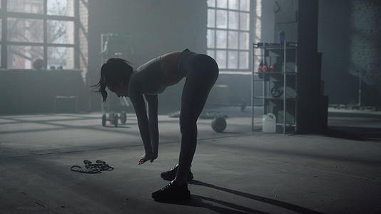 在健身房训练期间女性弯腰向前伸展视频的预览图