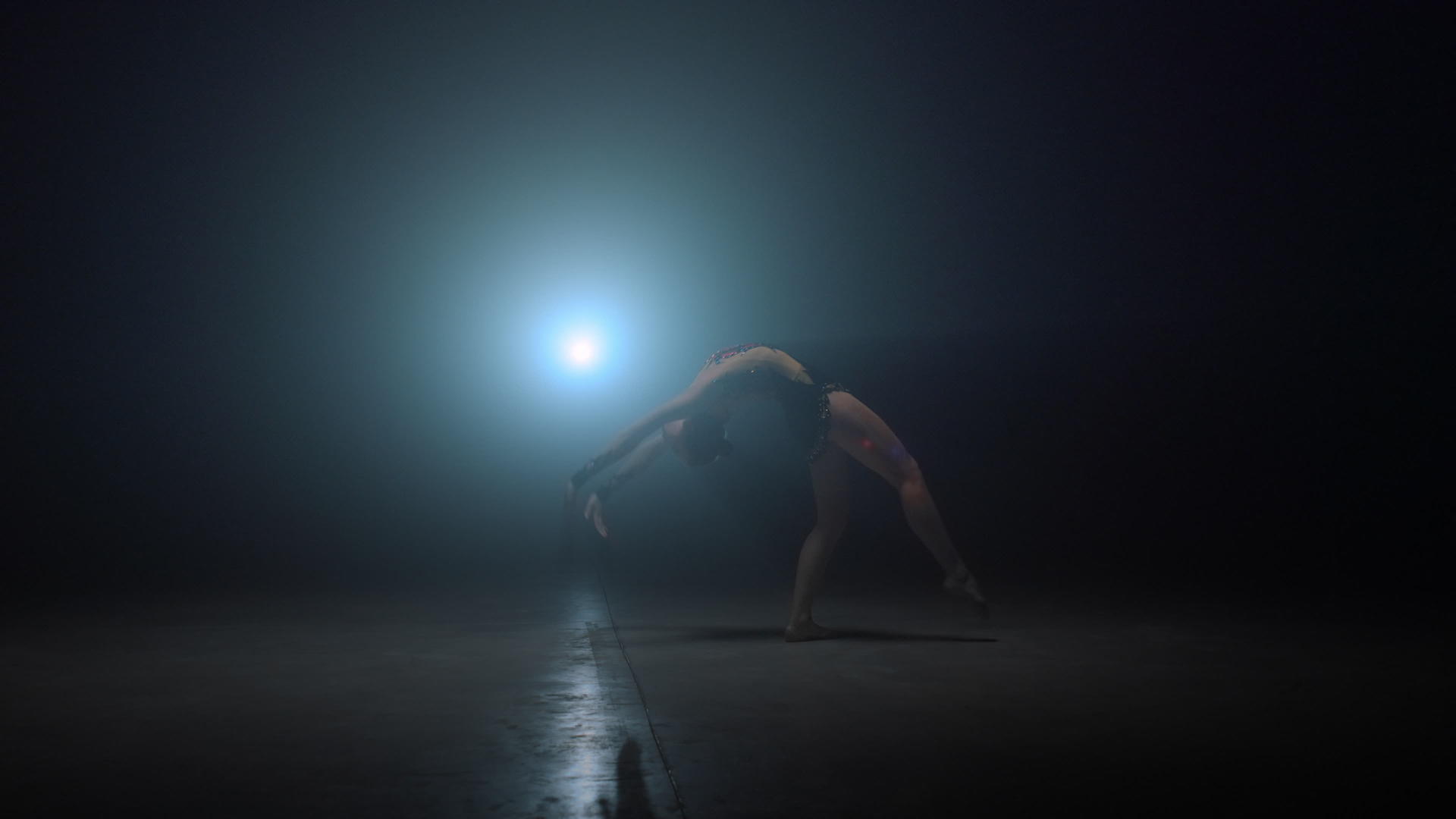 体操运动员女孩在黑暗的空间里翻跟头视频的预览图
