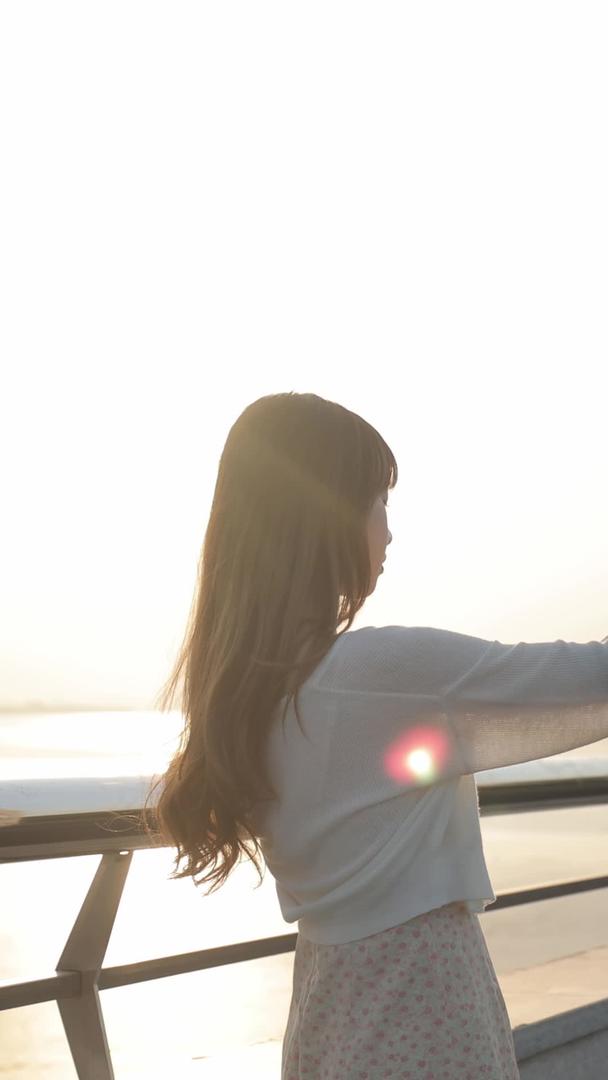 夕阳秀丽的江边游客女孩自拍身影视频的预览图