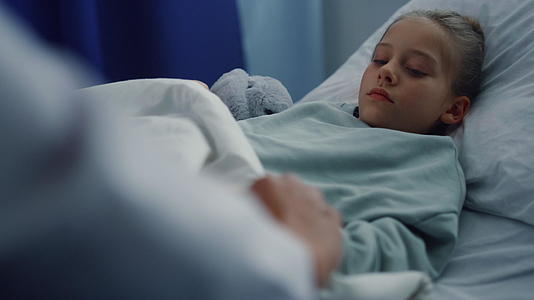 心烦意乱的女孩躺在病床上接受病房画像中的体检视频的预览图
