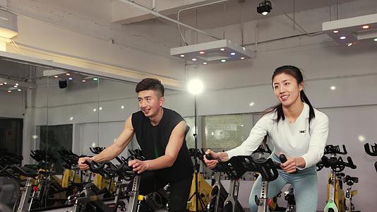 健身房骑动力单车的男性和女性视频的预览图