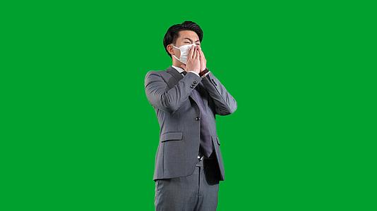 戴口罩的西装男士感冒打喷嚏绿幕视频的预览图
