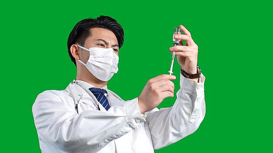 白大褂男医生用针管吸取药品绿幕视频的预览图
