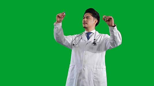 白大褂男医生观察药品绿幕视频的预览图