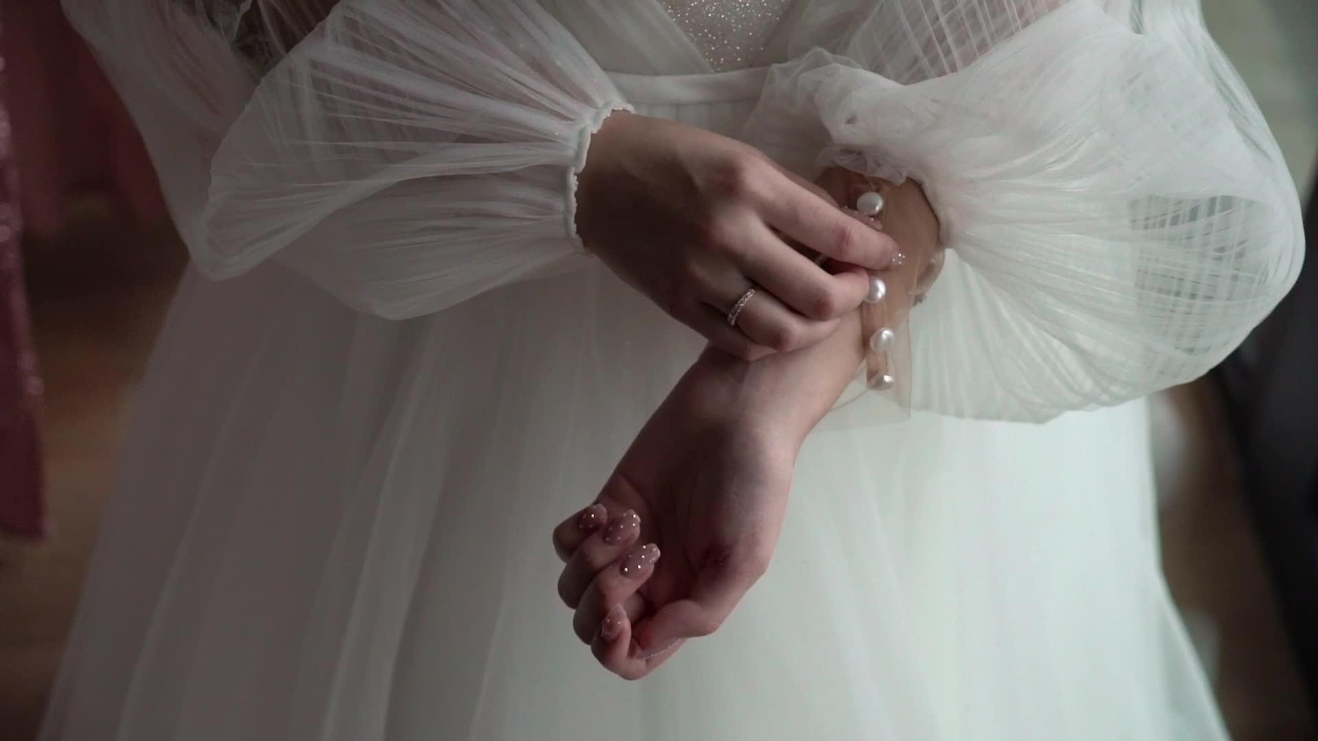 新娘在婚纱上扣上袖子穿上婚纱视频的预览图