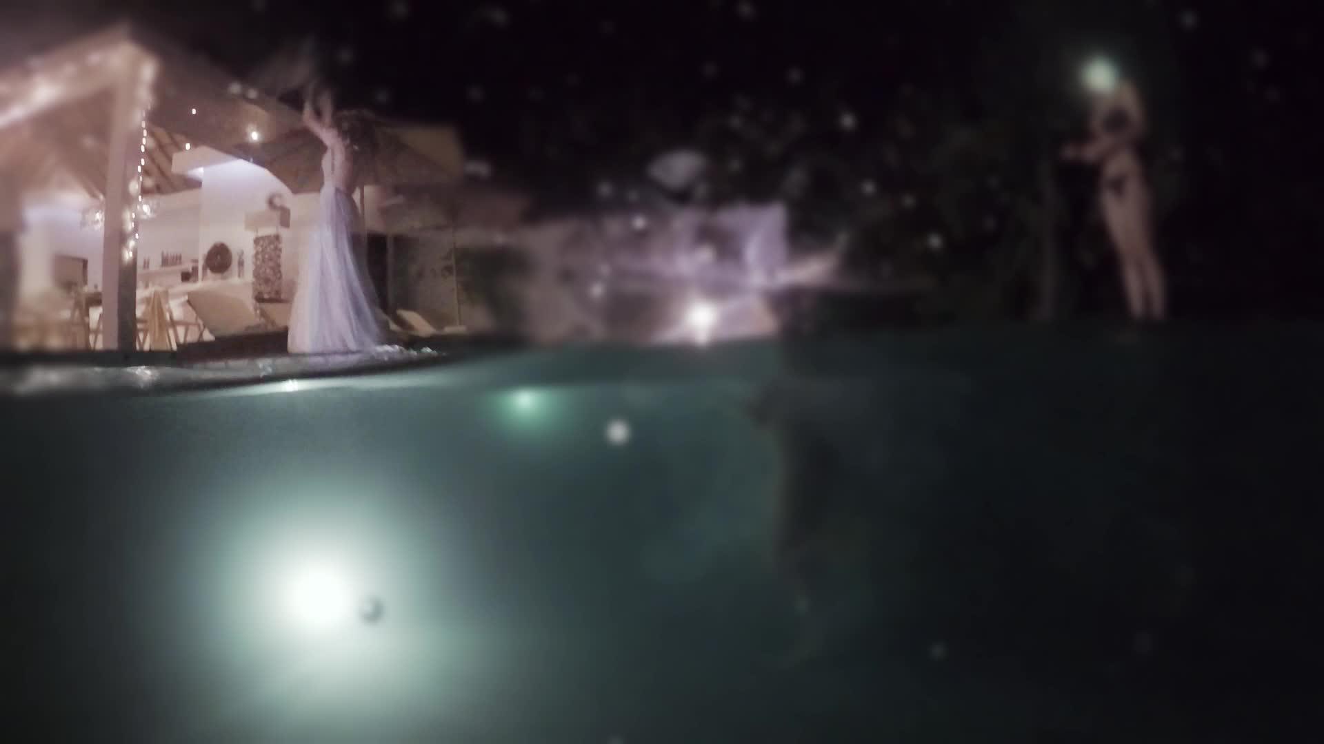 婚礼上新娘在晚上的游泳池派对上扔了一束花视频的预览图