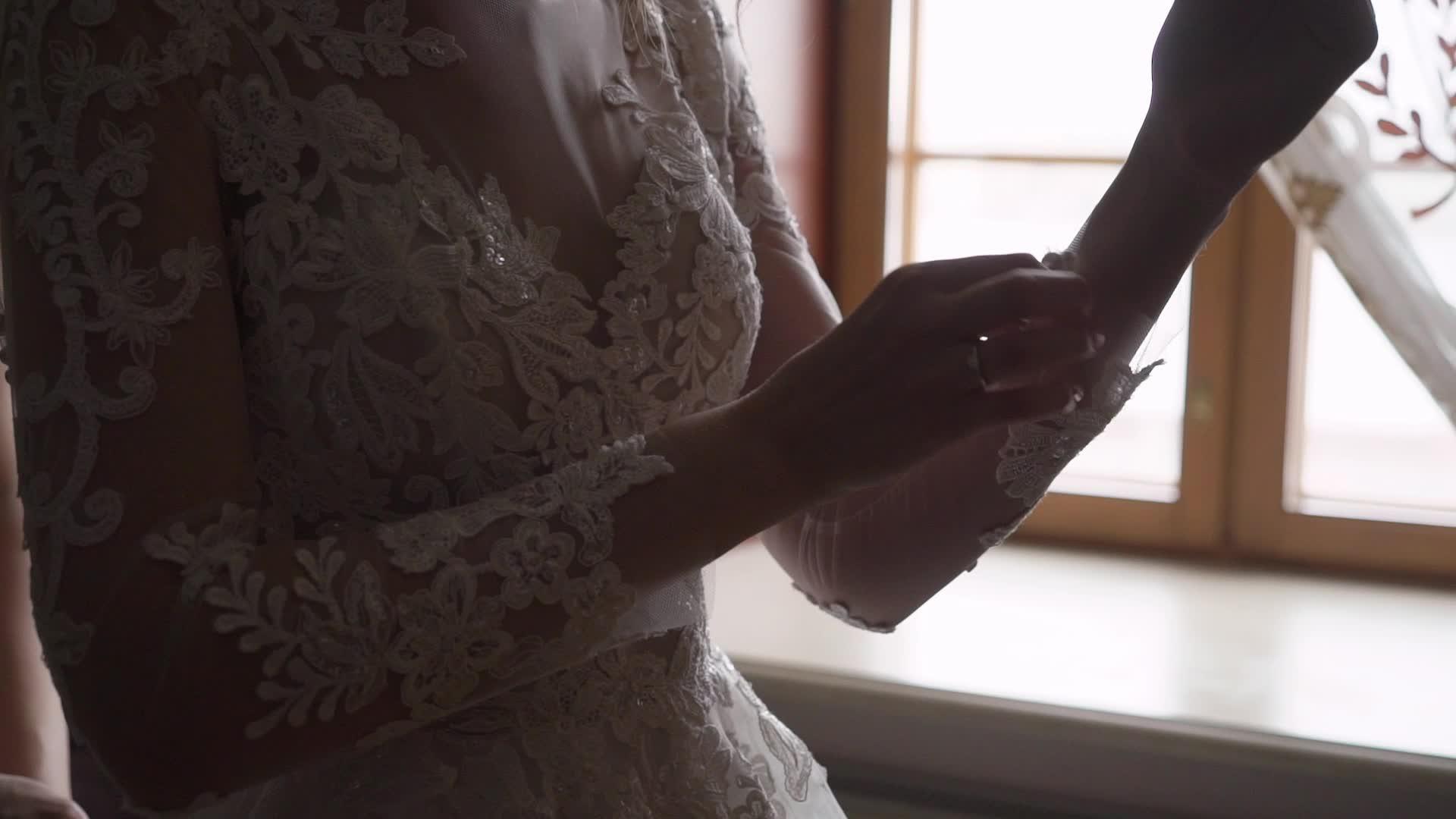 新娘在婚纱上扣上袖子穿上婚纱视频的预览图