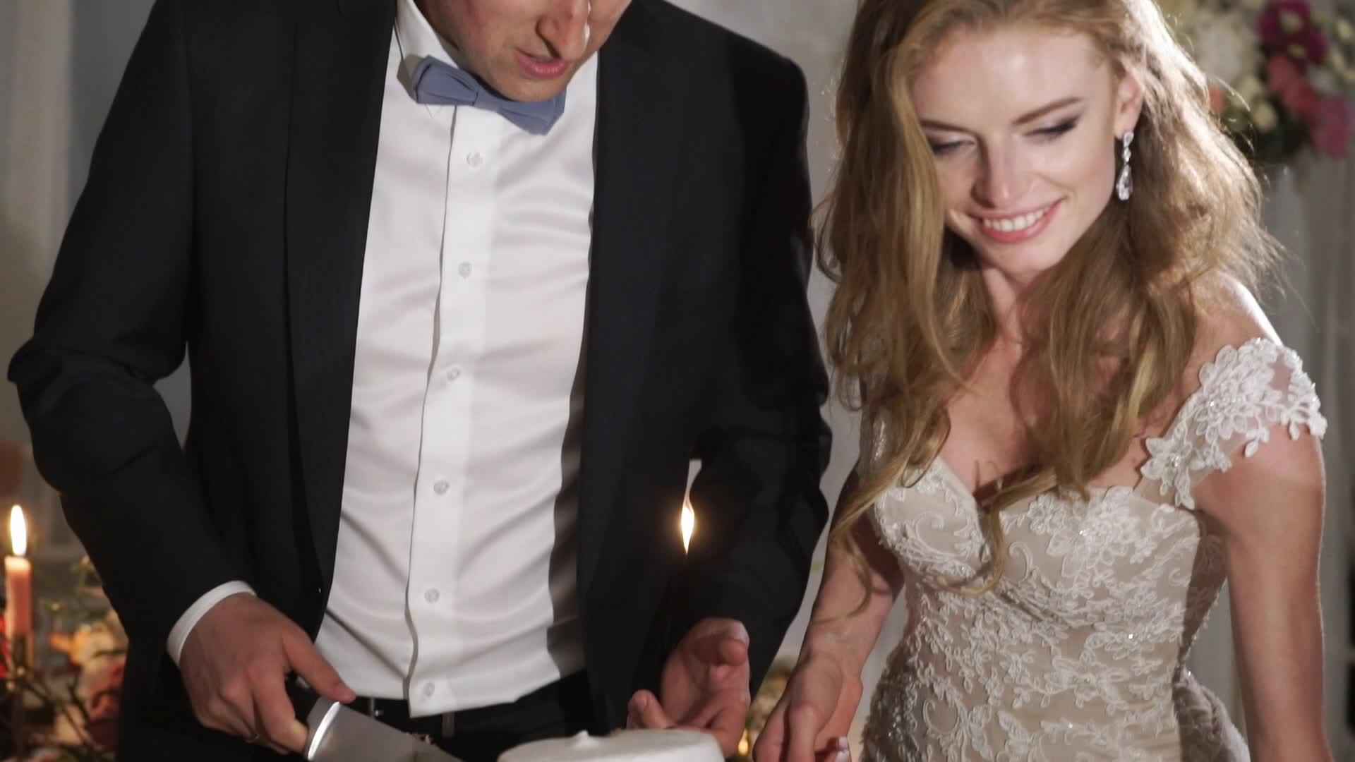 新娘和新郎在派对上切结婚蛋糕视频的预览图